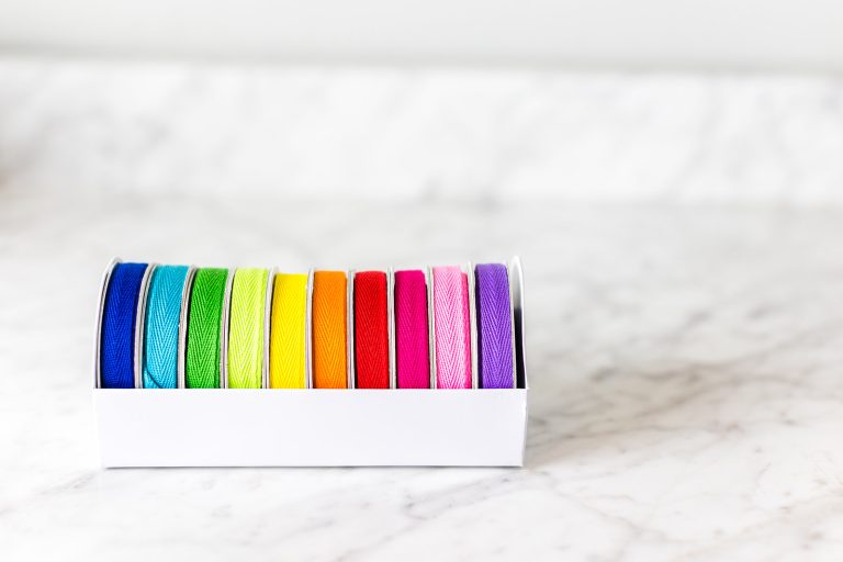 Rolls of colorful ribbons neatly organized in a box.