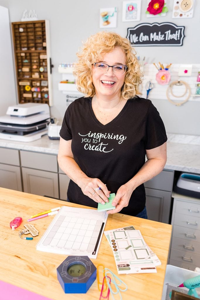Chelly in black shirt working in her office with planner.