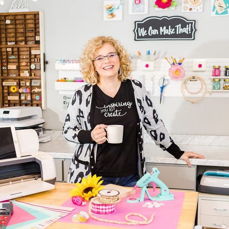 Chelly in studio with coffee and cricut with supplies on the desk.