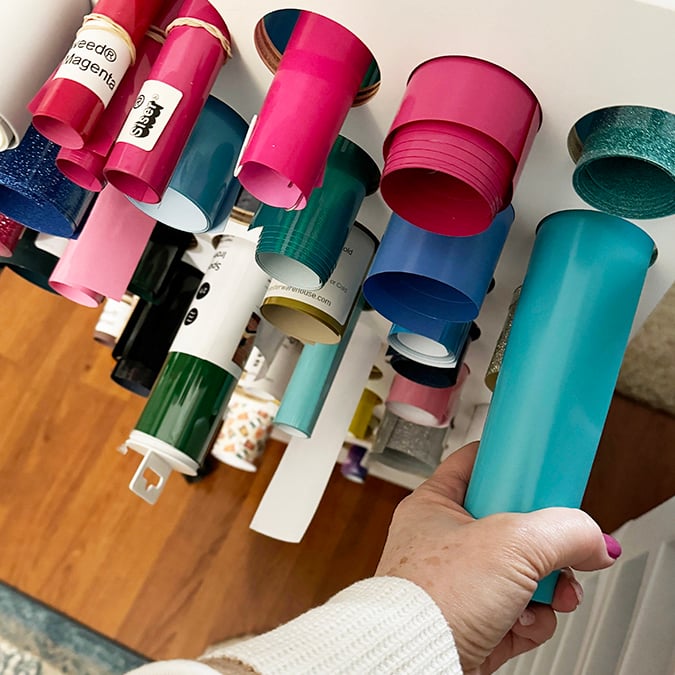 Rolled craft vinyl in a storage rack.