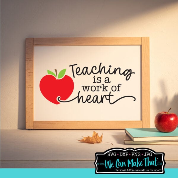 Framed sign with the quote “Teaching is a work of heart” next to a red apple, displayed on a wooden shelf with a book and apple, in warm lighting.