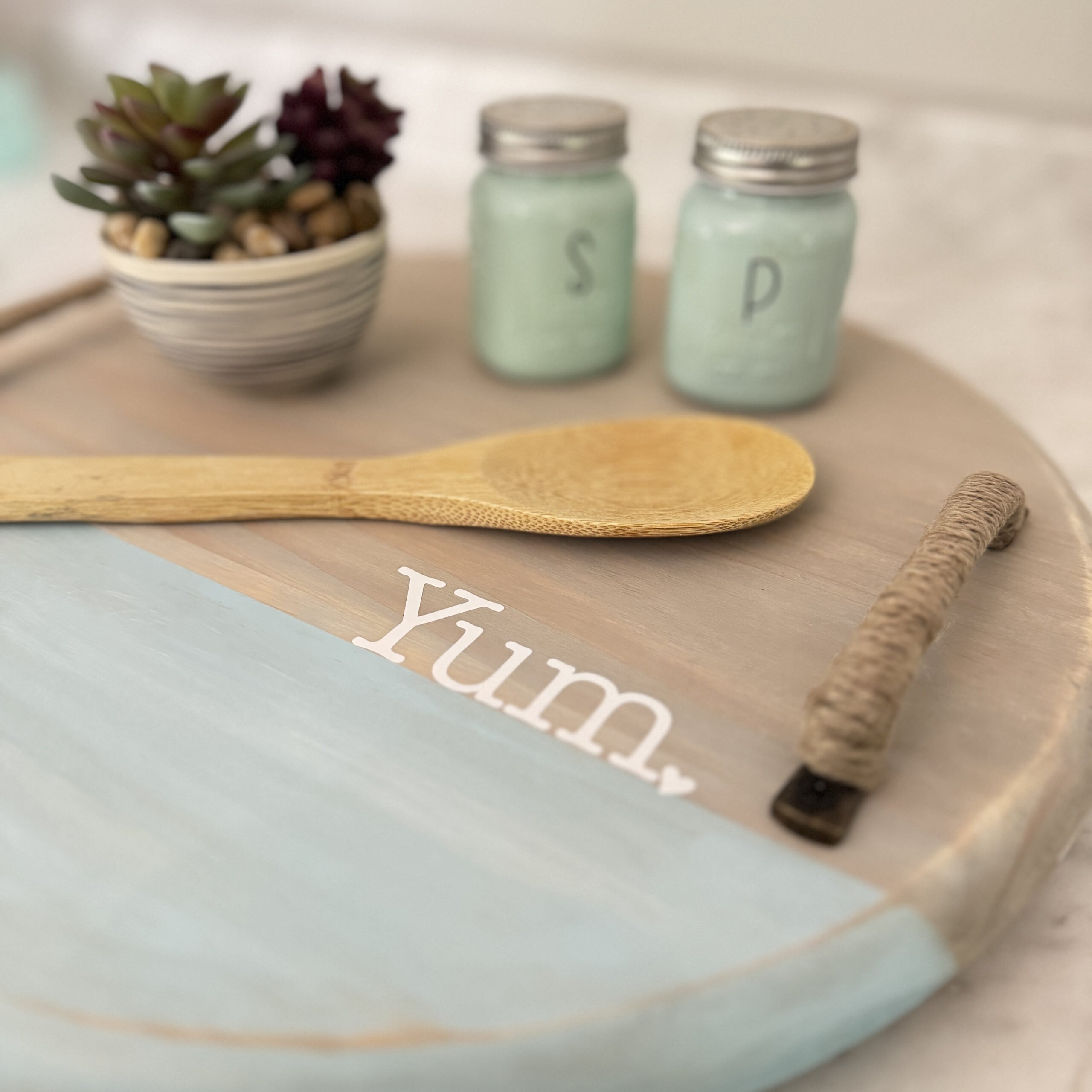 Hand-painted wooden tray with light blue center and small jars displayed on top.