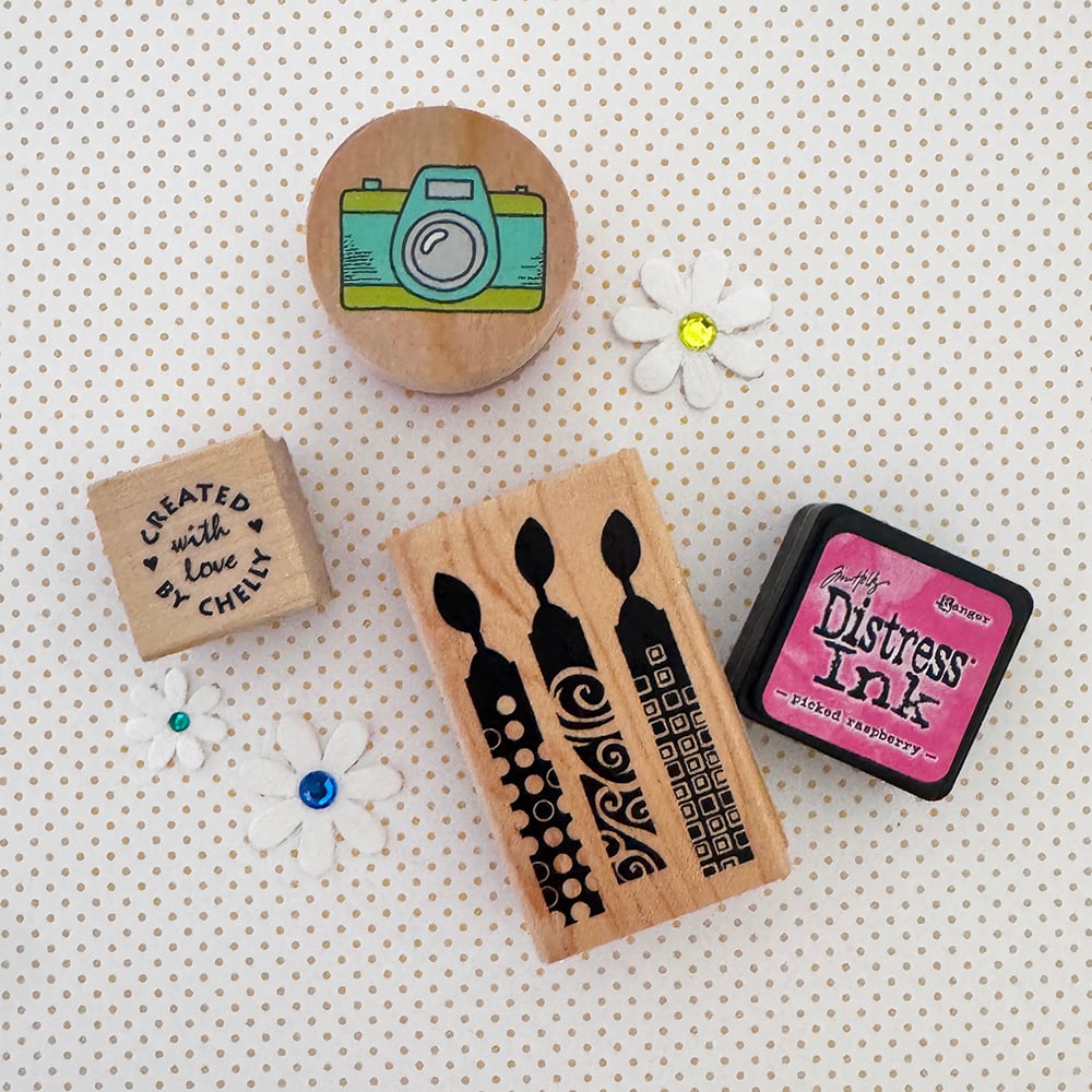 Stamps, ink and flowers for card making on a poka dot background.