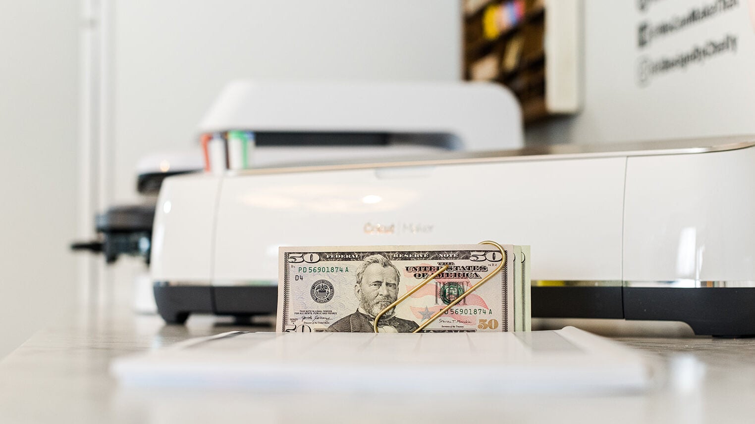 Heat press, Cricut machine and money.