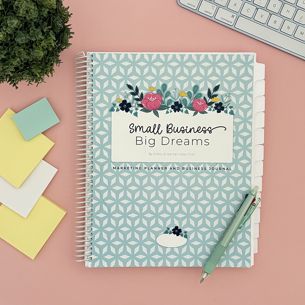 Small business planner on pink desk.
