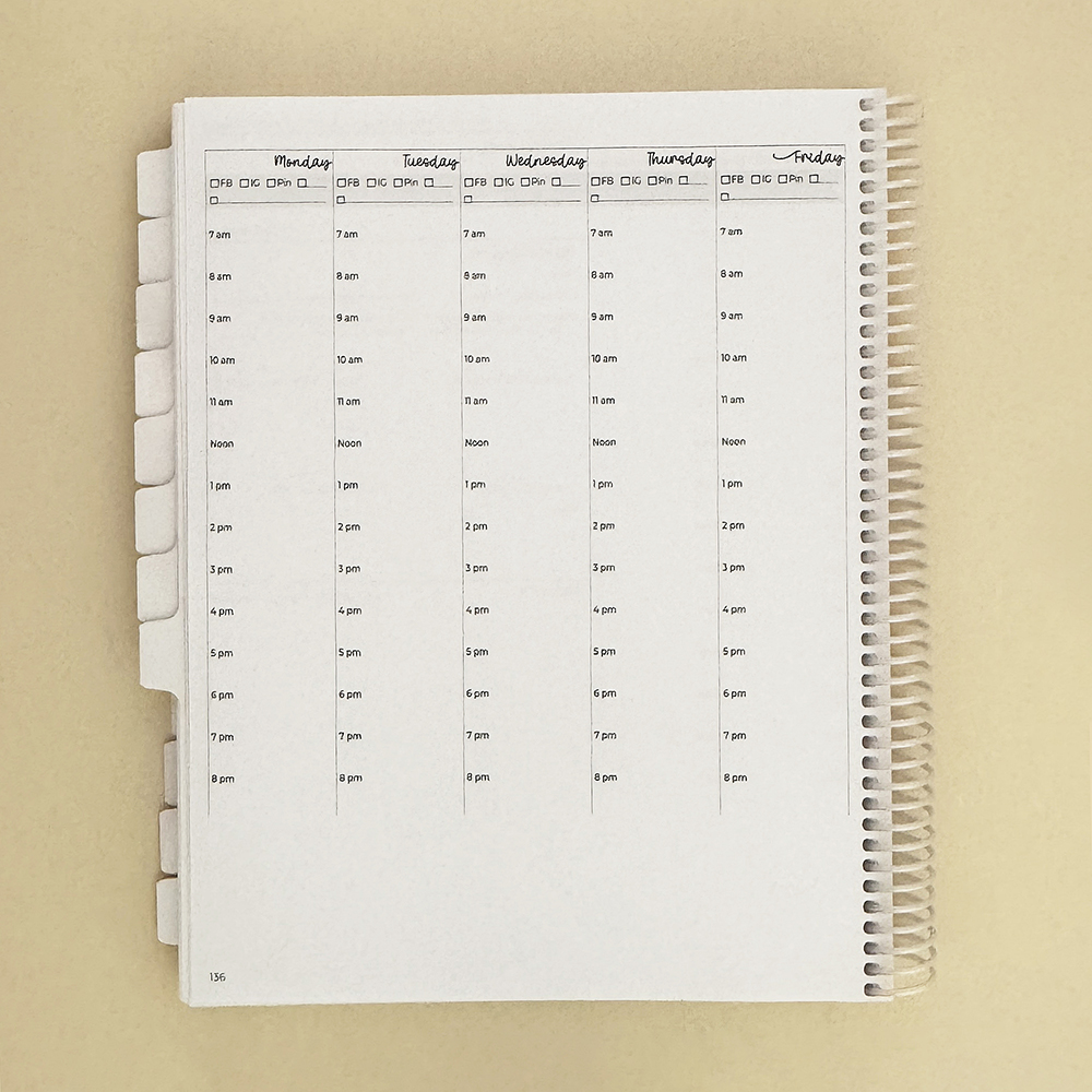 Small business planner on tan, open to weekly view.